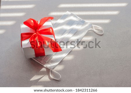 The gift box lies on a protective mask. Shopping concept during the coronavirus period.