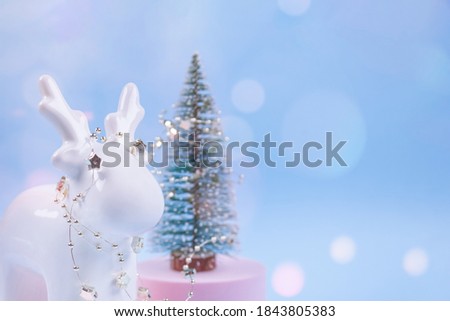 Christmas tree decorations on festive blue background with blurred bokeh and copyspace for your text. Christmas or New Year celebration concept. Christmas deer as traditional symbol