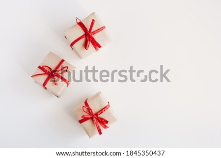 Gift boxes made from craft paper with red ribbon on white background with space for text.
