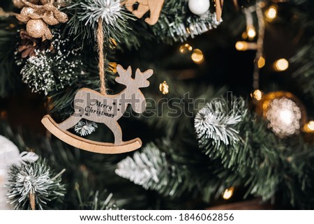 Christmas tree close-up with a hanging deer and the inscription merry Christmas