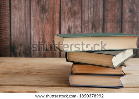 Stack of books on wooden background, many books piles, bookshelf