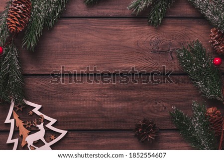 Pine branches and christmas toys on a wooden table, copy space, top view
