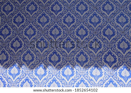 The rhythm of light and color on the wall of the church decorated with blue Thai ceramic tiles
