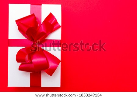 Top view White gift box red ribbon flat lay red background.Christmas concept.
