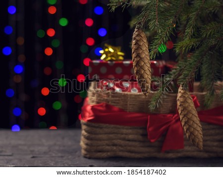A large gift basket under a Christmas tree on a bokeh background. Christmas and new year holidays.
