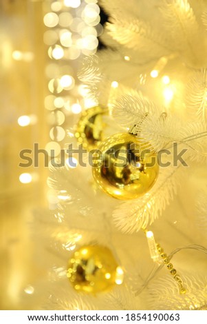 Golden balls on a white Christmas tree, blurred Christmas background bokeh