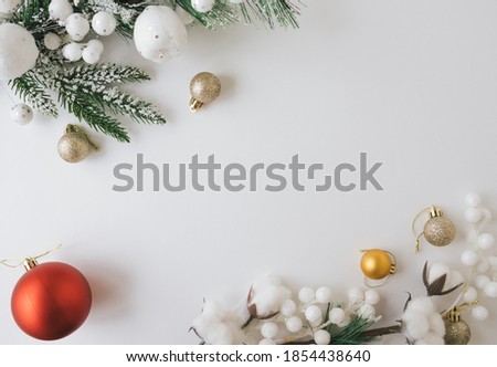 Flat lay with Christmas tree branch, toys and decorations on white background.