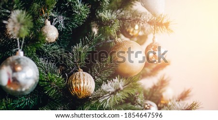Banner Christmas tree with decorations and illumination, sun glare bokeh in background.
