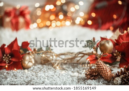 Cozy winter christmas background with snow and decorative pine cones on blurred colorful background.