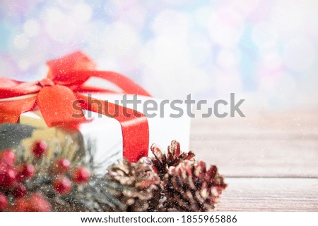 Christmas composition. Gift, for tree branches, red balls decorations on bokeh background.