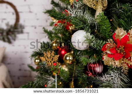 Beautiful christmas flower , red and white balls hanging on christmas tree.Christmas decorations. New Year decor for living room.tree branch decorated with lights, balls and tinsel.selective focus