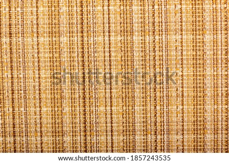 Factory fabric with yellow and red threads interspersed. Close-up long and wide texture of natural red fabric. Fabric texture of natural cotton or linen textile material