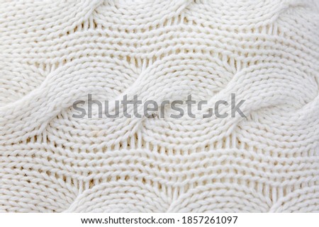 White wool knit with braids. Close-up. Background. Space for text. Hobby and craftmanship.