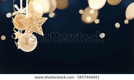 Hanging golden christmas festive balls decorations on black festive background with copy space
