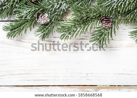 Winter fir tree with snow at white table. Top view with copy space.