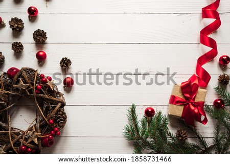 christmas wreath, toys, pine cones, gift box, spruce branches lie on a white wooden table 1