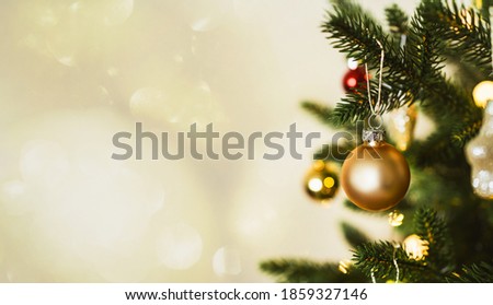 Beautiful Christmas tree with golden toys and garland lights. New Year and Christmas holidays.Closeup holiday and celebration  composition.Banner format