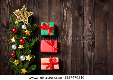 Beautiful Christmas green tree fresh fir branches and ornaments gift box and the star in-studio shot on black wooden background with copy space, New year card concept