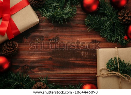 Christmas and new year with gift boxes, red balls and pine cone decoration on wooden table background top view with copy space.