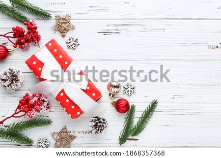 Gift box with ornaments on white wooden background