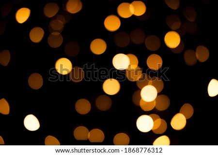 Bright yellow blurry lights on a black background. Bokeh for post-processing photos, design.