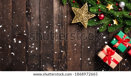 Christmas holiday garland border, Top view flat lay tree fir branches, and Xmas ornament bauble decor, the stars and gift box on black table wood background with copy space, Happy new year day concept