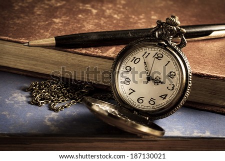 Pocket watch with antique book and pen,vintage color.