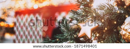 Christmas and New Year Concept. Holiday background and banner size image. Snowing outside and amazing Xmas decorations on real fir branches.