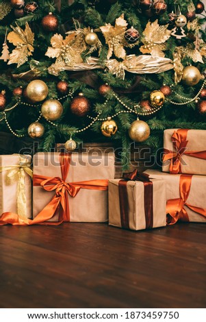 Gift boxes and golden Christmas tree, wrapped presents and decor in country style as holiday home decorations