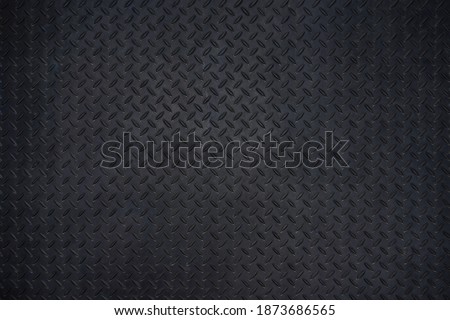 Close-up photos of Black metal floor plate texture details background. Dark wall and copy space.
