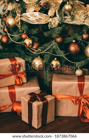 Gift boxes and golden Christmas tree, wrapped presents and decor in country style as holiday home decorations