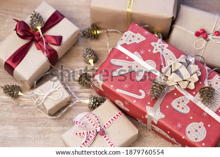 Christmas gift boxes and glowing garland on wooden background. New Year presents.