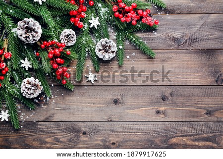 Fir tree branches with christmas ornaments on brown wooden table