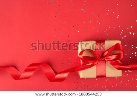 Above flat lay close up view photo of beautiful gift box with red ribbon and confetti isolated bright background with empty blank space