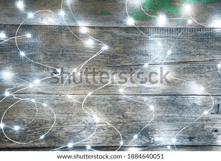 Burning lights garland on a wooden background. Side view. The concept of abstract backgrounds.