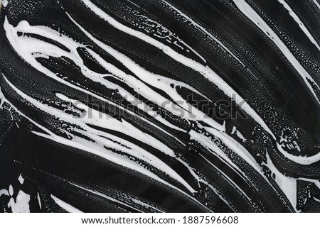 Foam and soap on black background. Glass Cleaner