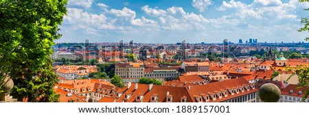 Prague red roofs and dozen spires of historical Old Town of Prague. Cityscape of Prague on a sunny day. Red rooftops, spires and the Charles Bridge and Vltava River in the background. Prague, Czechia.