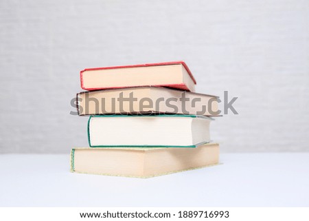 A stack of books lying on a white table, reading and education concept.