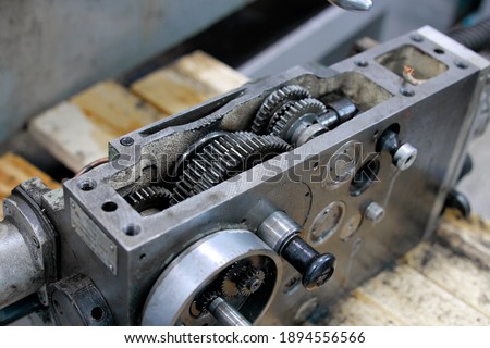These are metal lathe parts. It is a steel mechanism with gears. Service for disassembly, maintenance and repair of machines in the workshop.