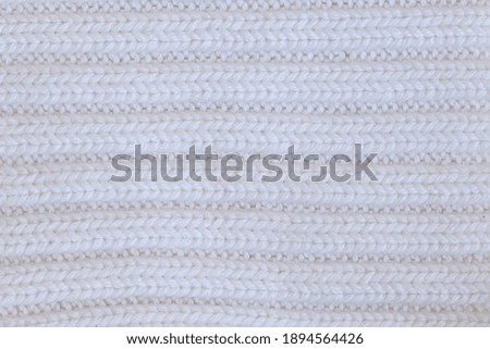 The texture of a light knitted sweater fabric.