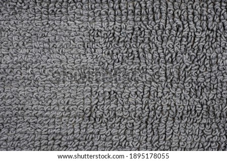 The woven backing of a bath rug in close-up. Gray cotton texture rug top view.