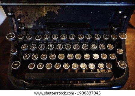 Close up of ancient vintage typewriter keyboard on wooden table with rusty texture which presenting ages.