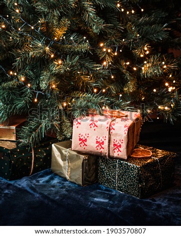 Presents gifts under the Christmas tree decorations with fairy lights 