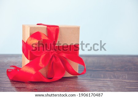 Gift box red bow on wood table. Copy space.