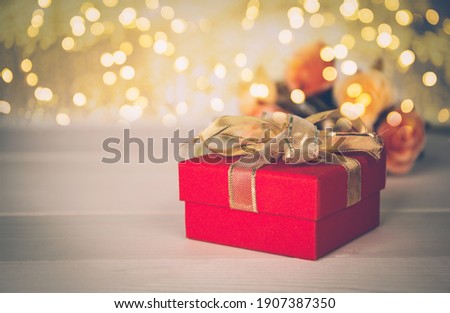 Red gift box and flower on wooden table with bokeh background, love and romance, presents in celebration and anniversary with surprise on desk, happy birthday, copy space, valentine day concept.