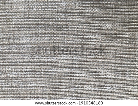 Woven texture of gray-beige fabric. Selective focus 