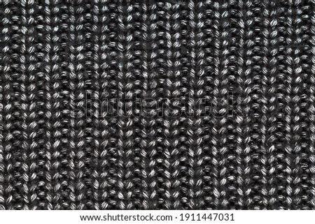black and silver knitted fabric with folds texture background