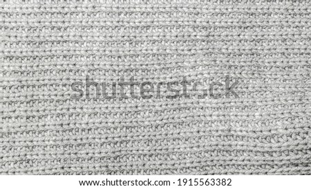 Texture of grey woolen knitted fabric background