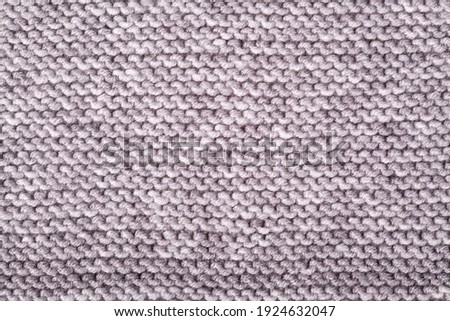 Knitted pattern of gray yarn, knitted plaid. Needlework, handicrafts, hobbies, creativity, DIY
