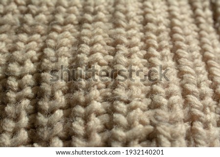 Close-up of a large knitted jumper. English knit. Beige, natural colour.